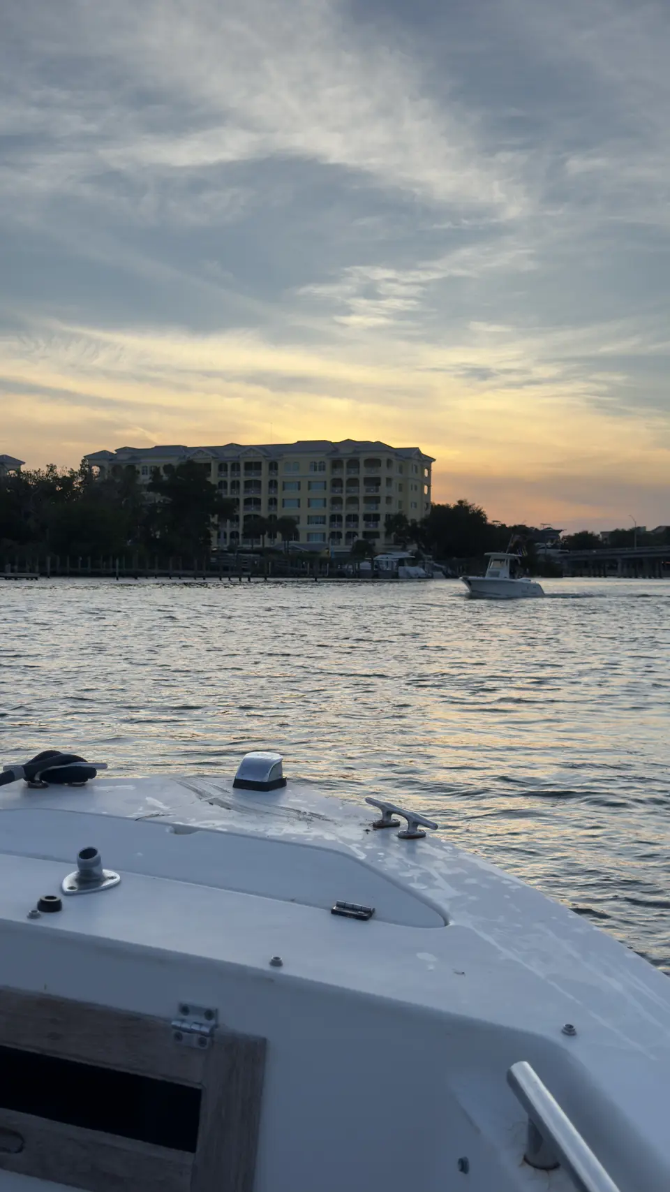 Boat bow cruising the Intracoastal toward waterfront condos at sunset