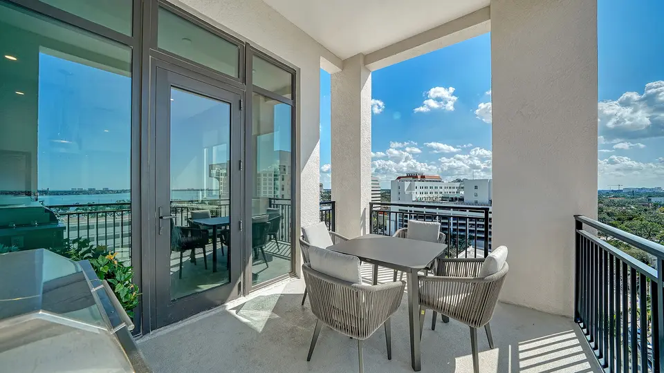 Covered balcony with dining set and views of the bay and city