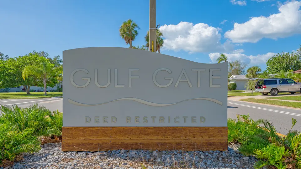 Gulf Gate neighborhood entry sign with landscaping under a blue sky