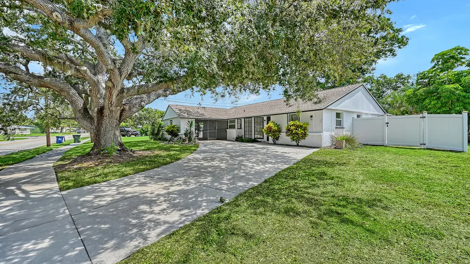 Single-story ranch home on a corner lot shaded by a large live oak