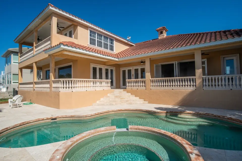 Two-story waterfront home with a heated pool and spa