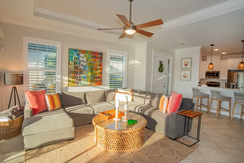 Furnished living room with colorful art and an open kitchen