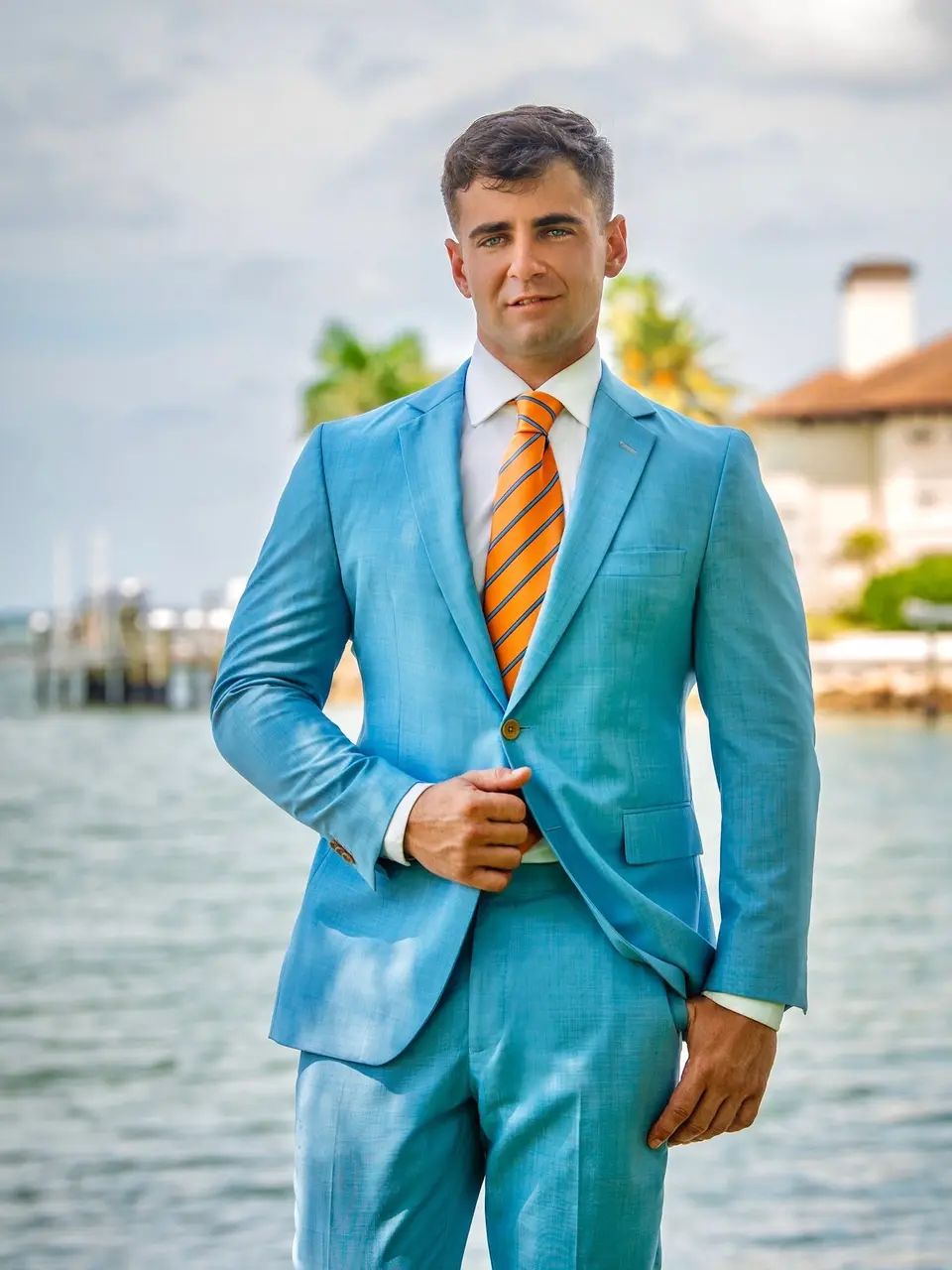 Richard in a light blue suit on a waterfront dock