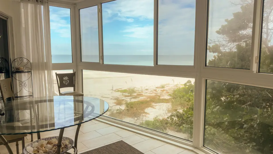 Corner windows looking straight onto white sand beach and the Gulf