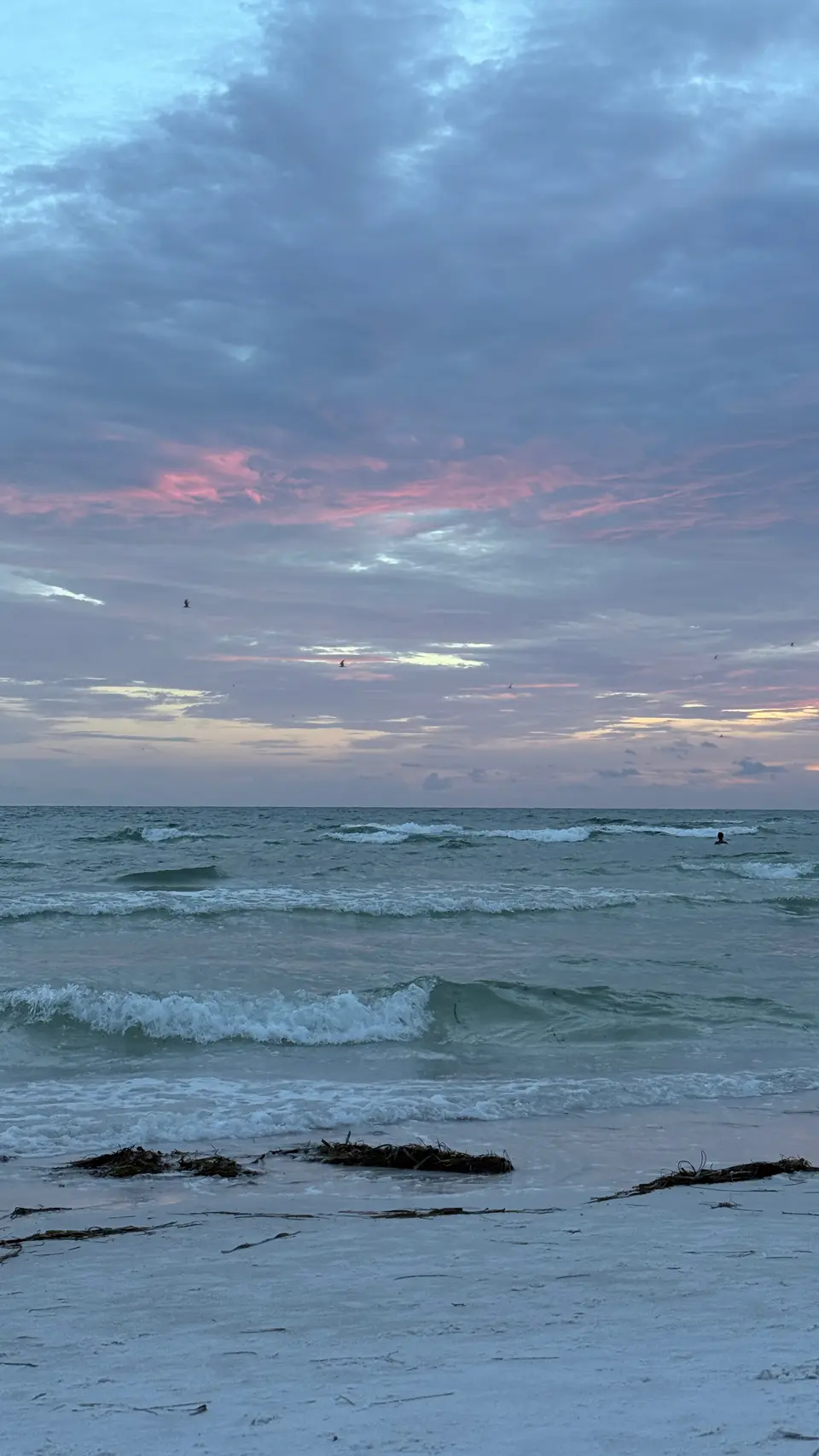 Evening clouds over green Gulf waves breaking on Lido Key beach