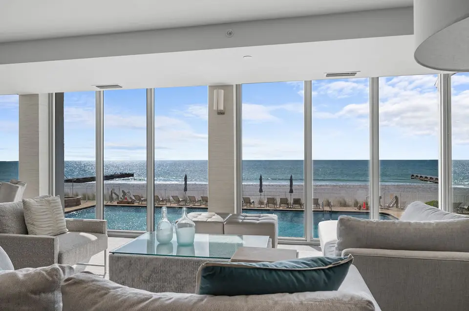 Clubroom lounge with floor-to-ceiling windows facing the pool and Gulf