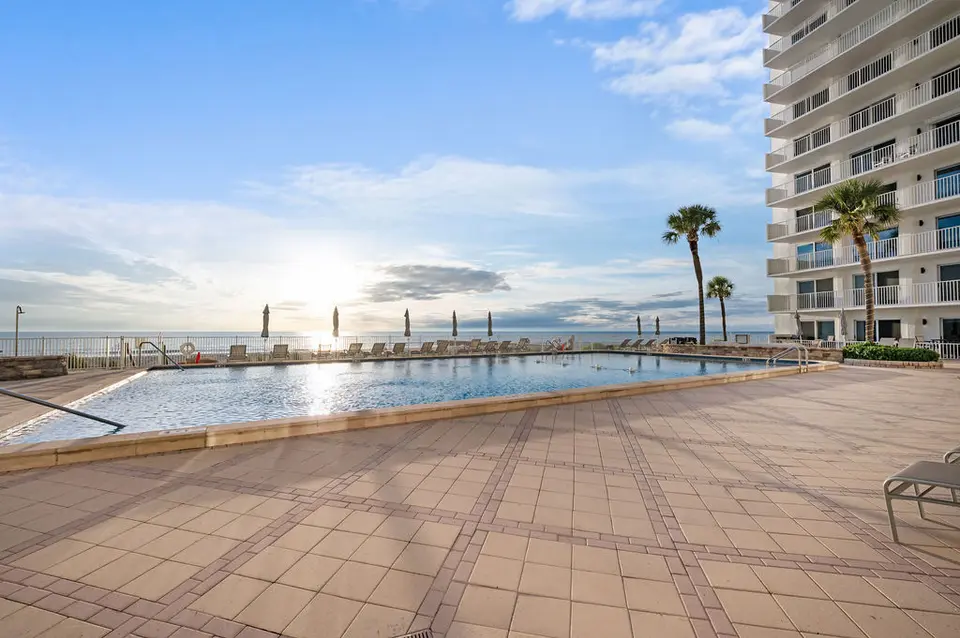 Gulfside pool deck with lounge chairs and open water views