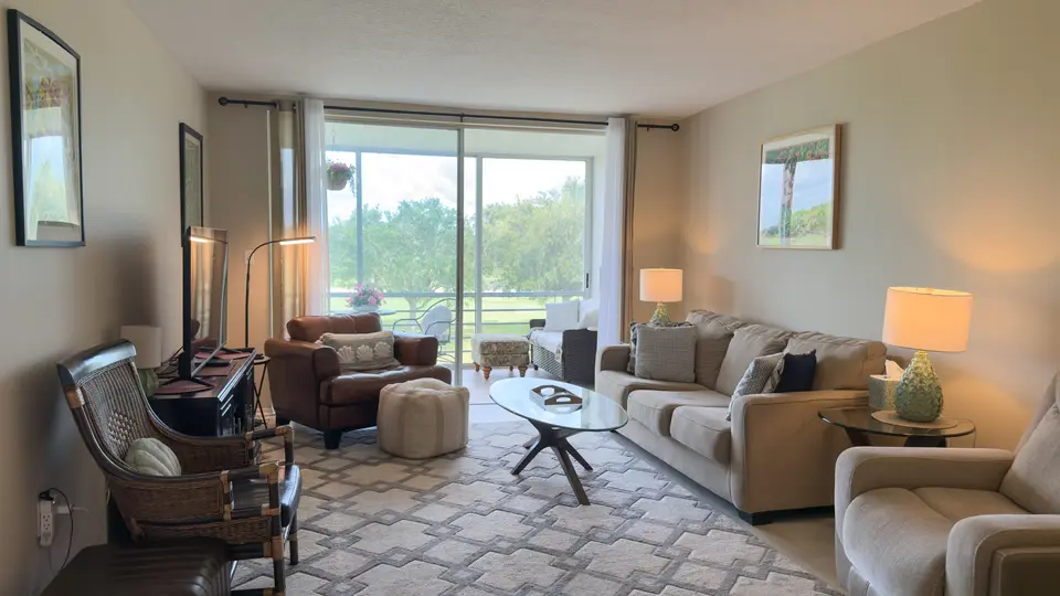 Condo living room with sliding glass doors to a golf course view