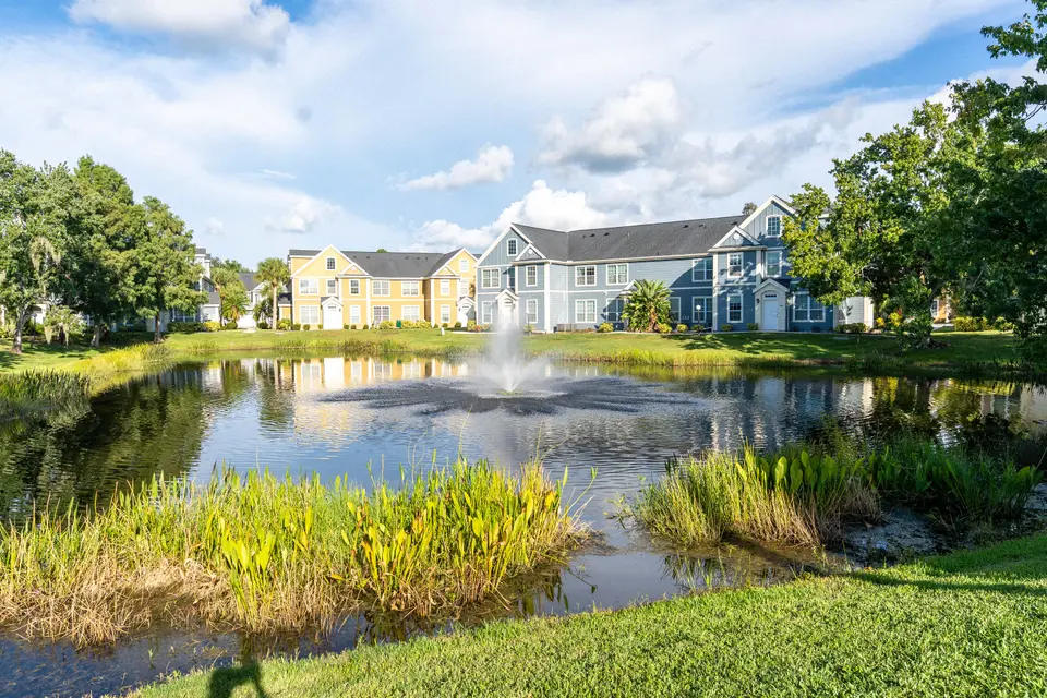 Community pond with fountain and townhomes along the far shore
