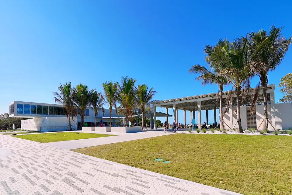 Siesta Beach Park pavilion with palm trees, lawn and paver walkway